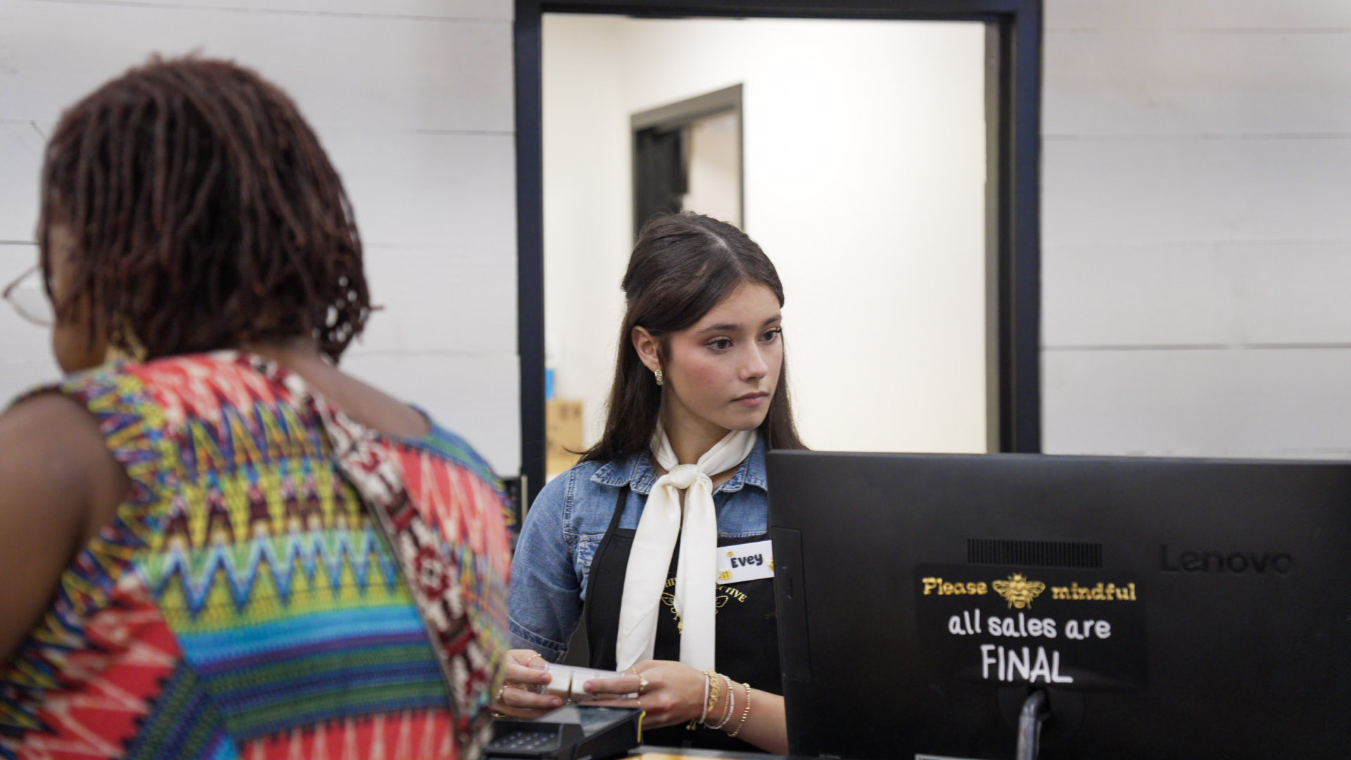 Shopper checking out at the NRH Hive Collective register while a team member reviews a purchase
