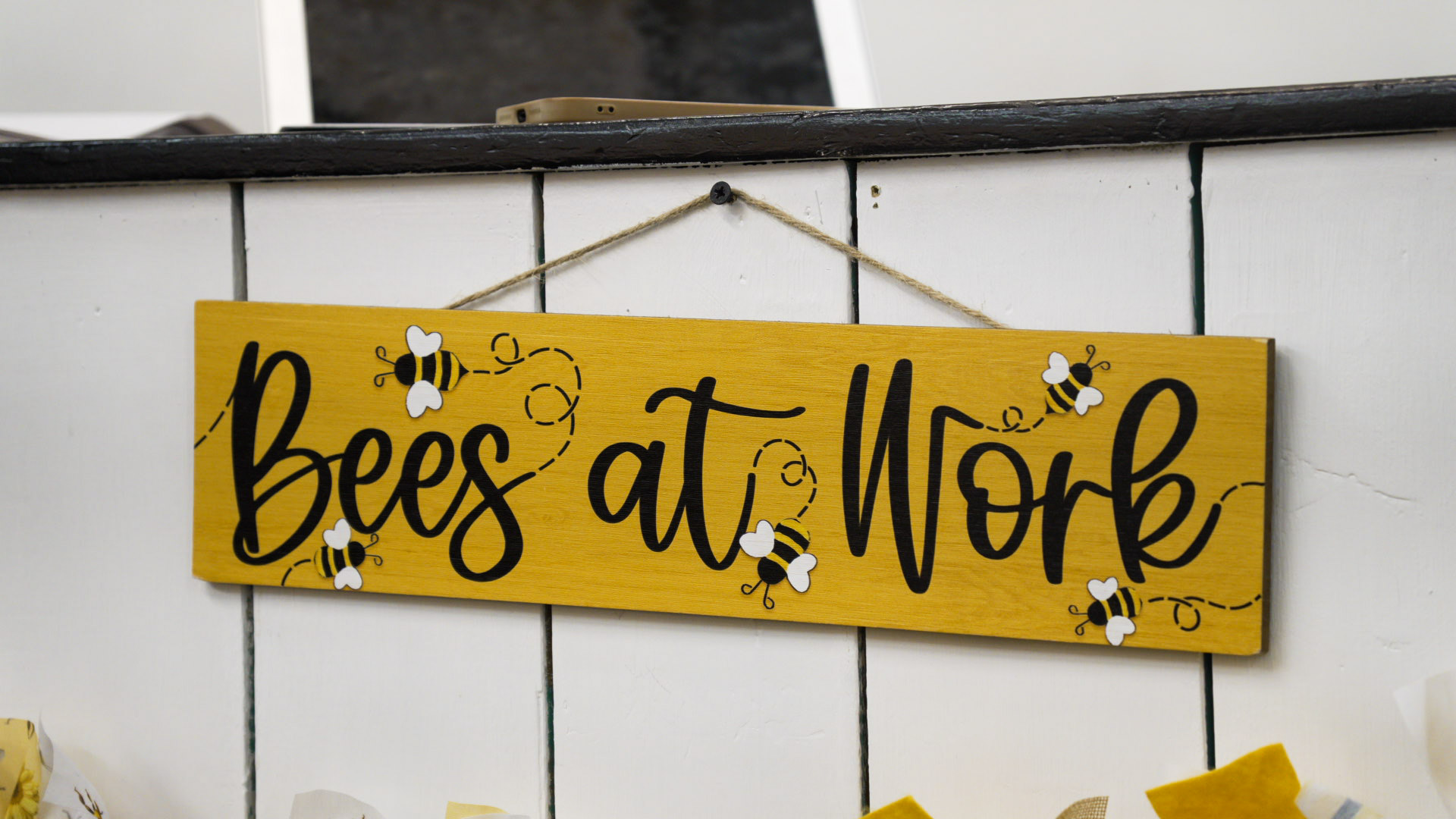 Bees at Work sign hanging in a vendor booth at NRH Hive Collective